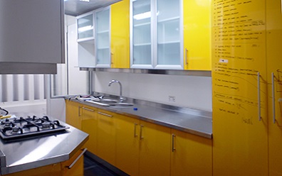Muebles de cocina81 a medida con cubierta de Acero inoxidable puertas Lamitech amarillo en Vitacura